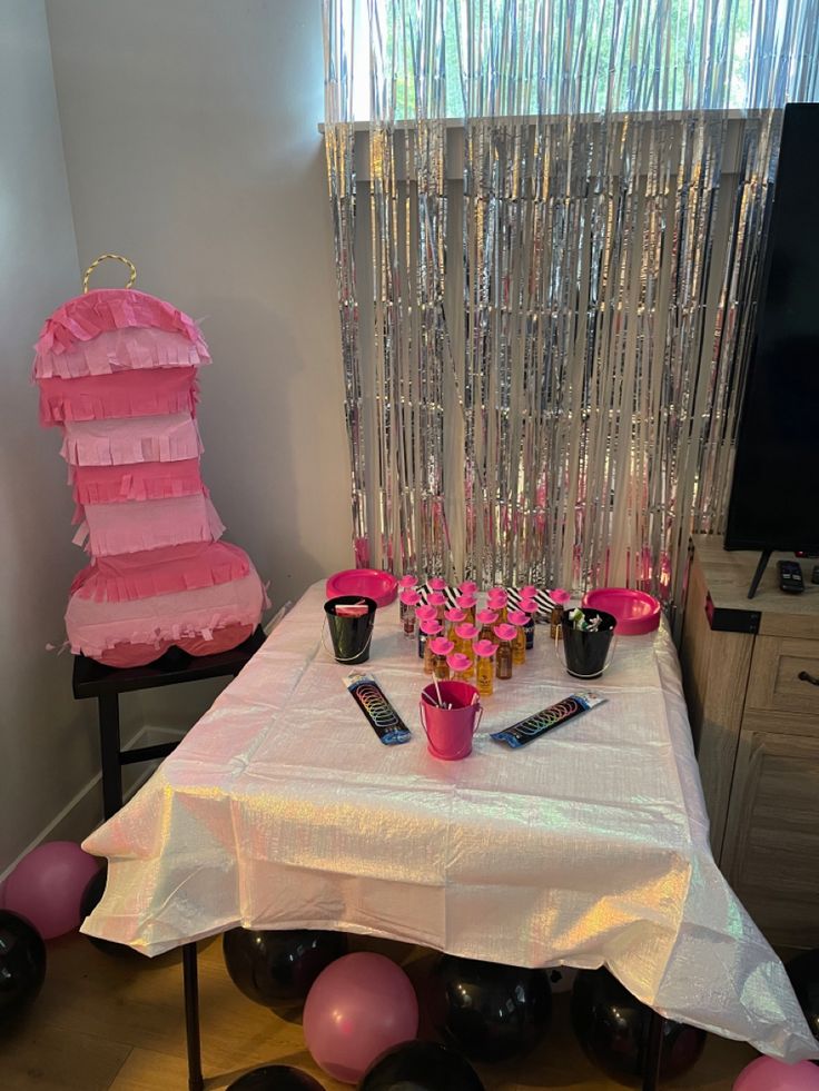 the table is set up with pink and black decorations