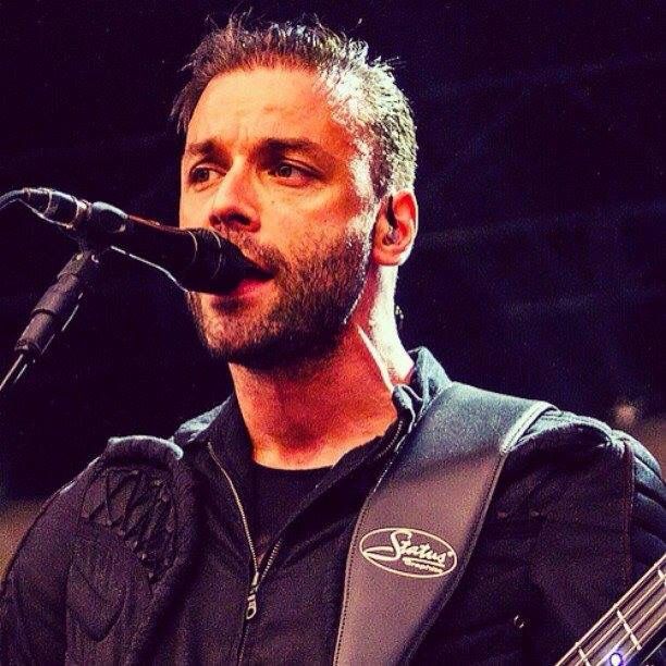 a man holding a guitar while standing next to a microphone