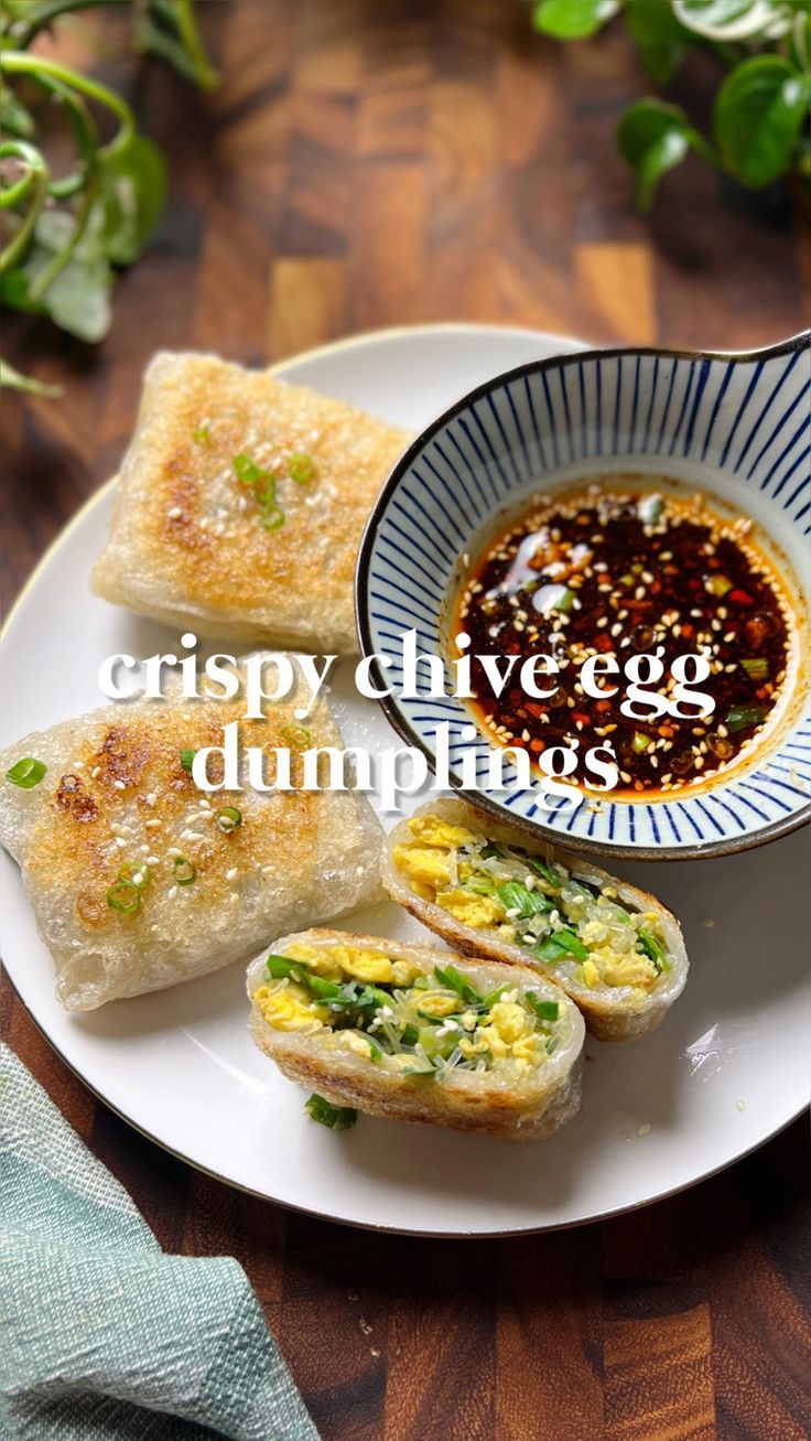 some food is on a white plate with a blue and white bowl next to it that says crispy olive egg dumplings