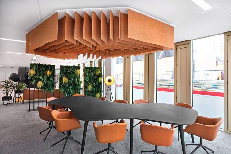 a conference room with orange chairs and an oval table