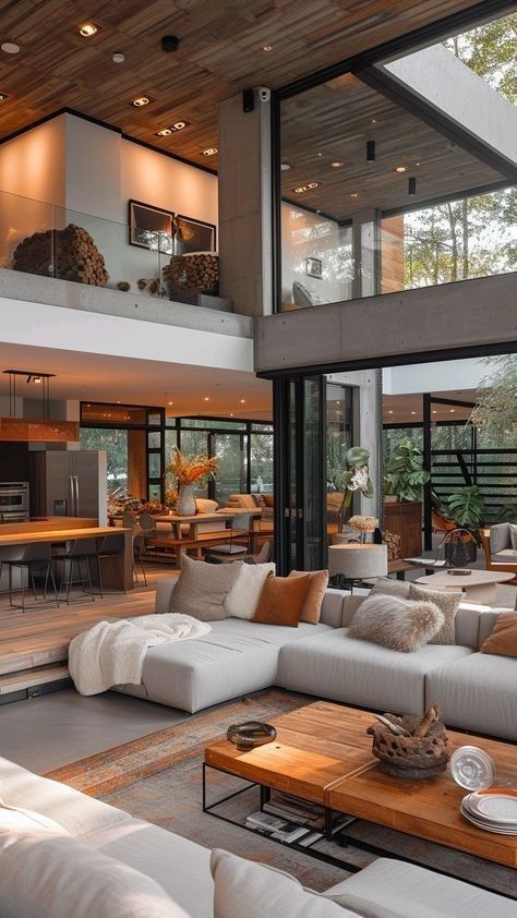 a living room filled with lots of furniture and large glass doors leading to an open floor plan