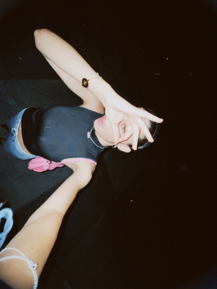 a woman in black shirt laying on floor next to scissors