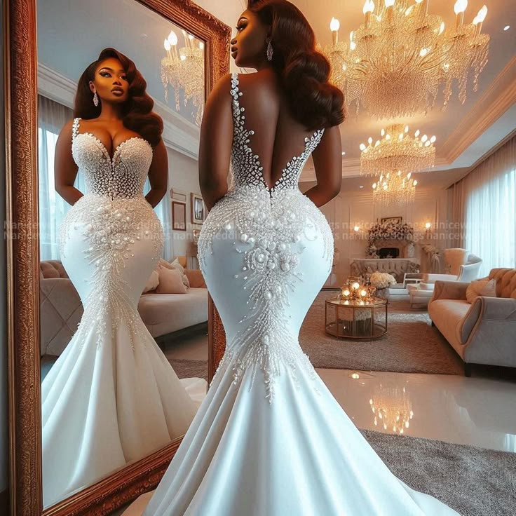 a woman in a white wedding dress looking into a mirror with her back to the camera