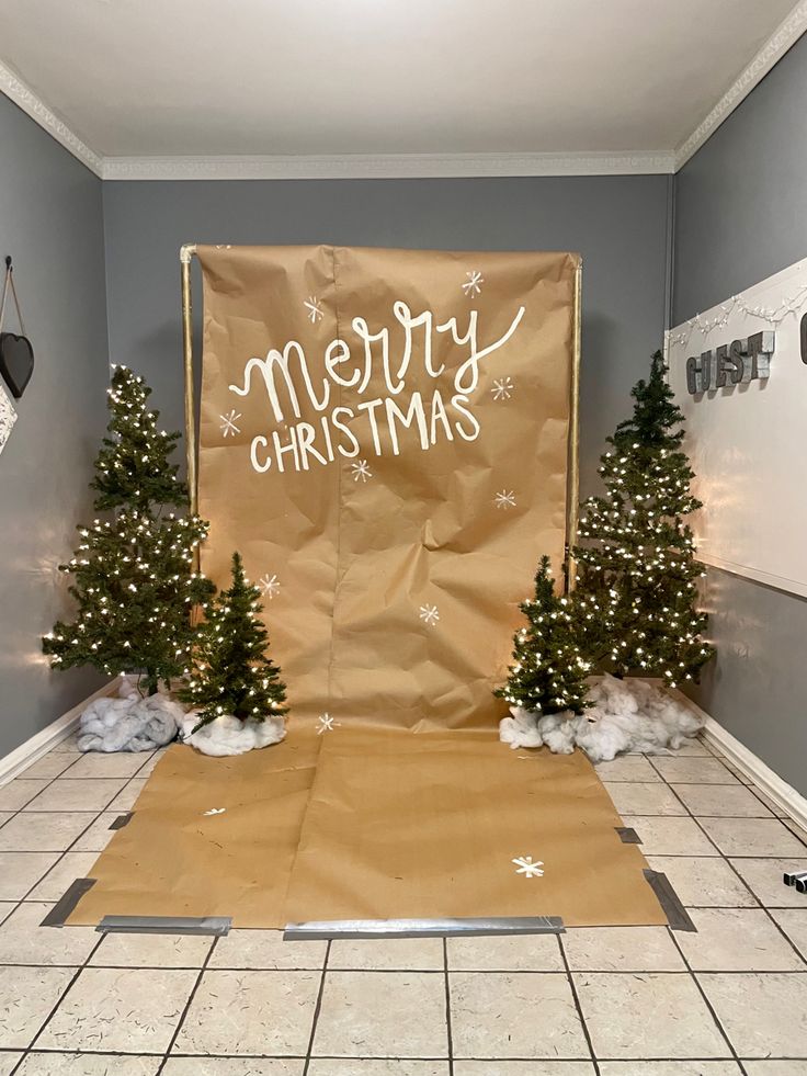 a room with christmas decorations on the floor and a sign that says merry christmas in front of it