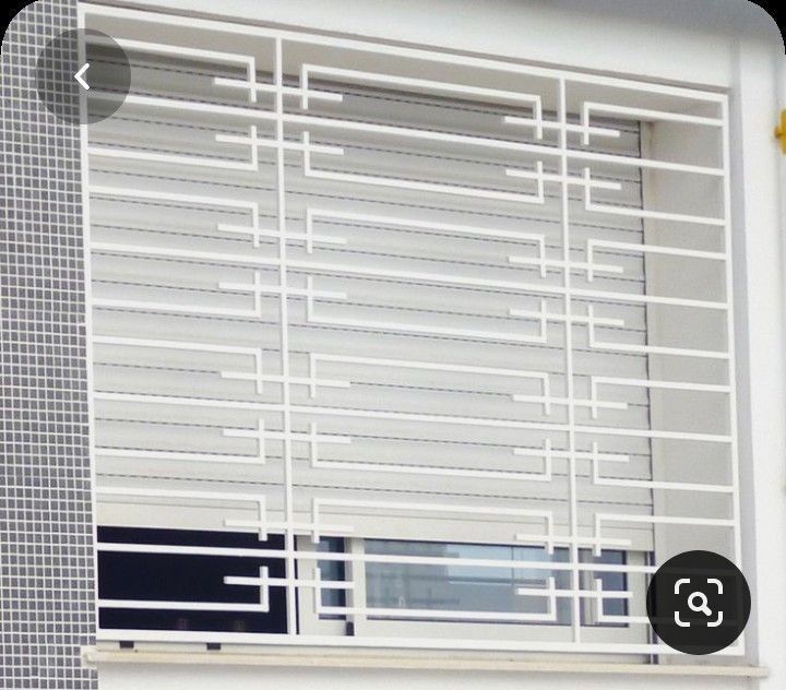 a cat sitting on top of a window sill in front of a white building