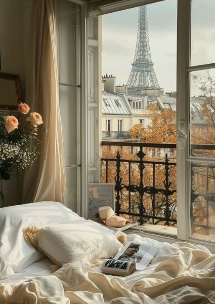 a bedroom with a view of the eiffel tower from it's window