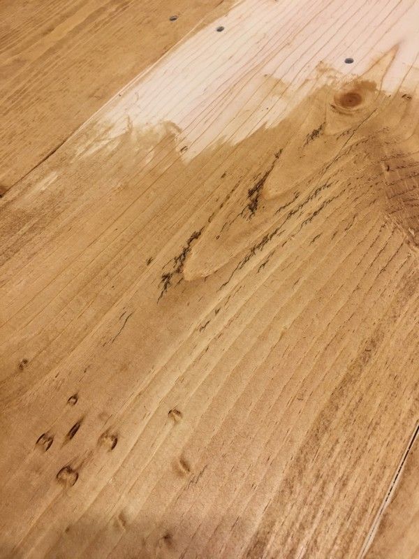 a close up view of a wooden table with some stains on the top and bottom