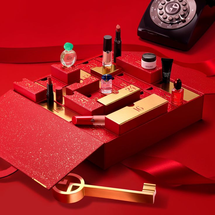 an assortment of cosmetics and lipstick on a red surface