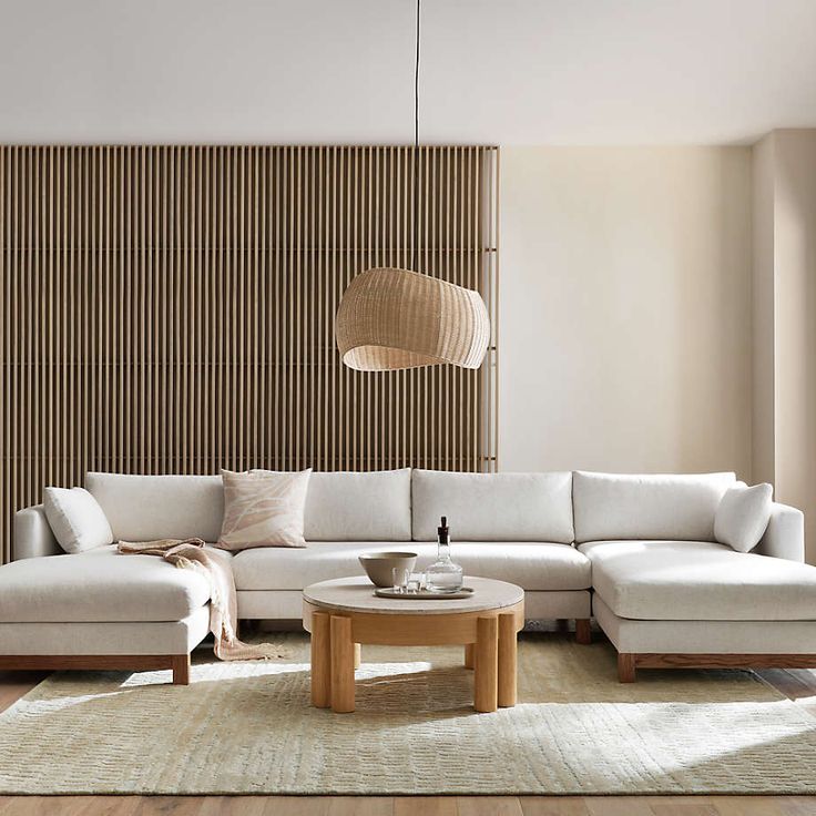 a living room filled with furniture and a large wooden paneled wall behind the couch