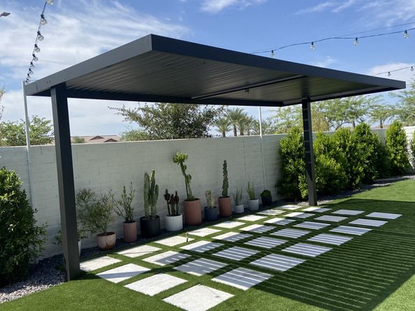 an outdoor patio with grass and potted plants