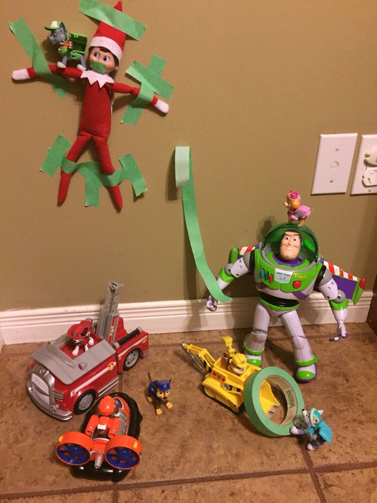 some toys are laying on the floor in front of a wall with two elfs