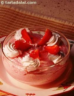 a dessert with strawberries and whipped cream in a glass dish on a place mat