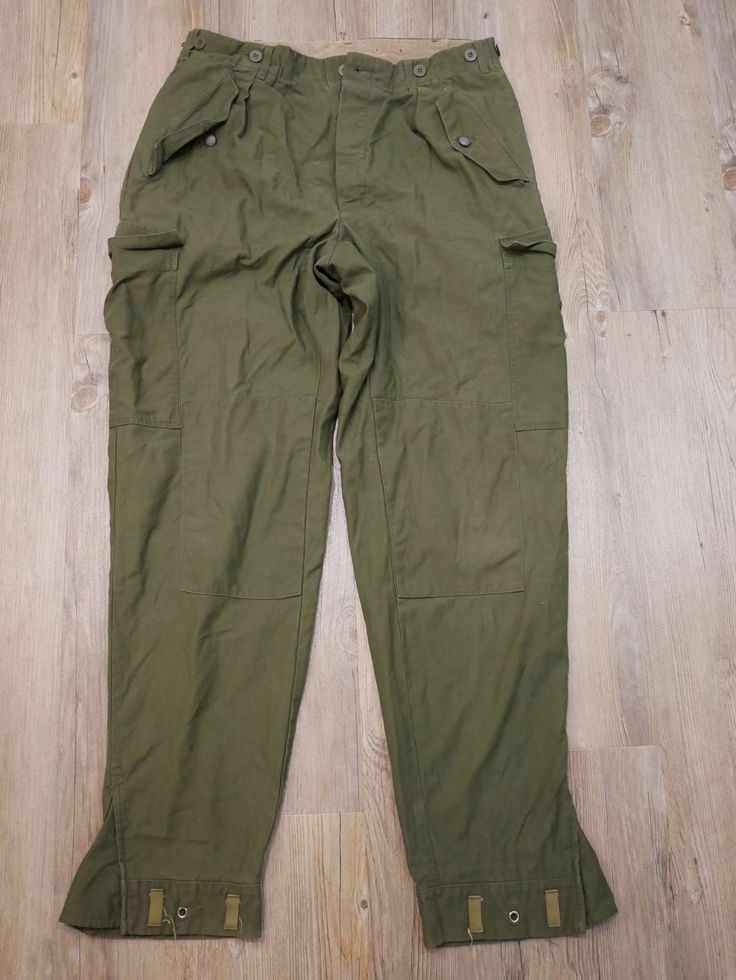 Military pants There are buttons as a closure. There are buttons all around the waist. Two button pockets on the side. Two flap pockets on the sides. A button pocket on the right buttock. The bottom of the pants at a bellows. size : C 152 Height: 42 cm Length: 113 cm Length between legs: 86 cm Weight: 870 grams. Combat Cotton Trousers, Combat Style Cotton Trousers, Combat Cotton Pants With Hip Pockets, Military Style Full-length Parachute Pants With Pockets, Cotton Combat Pants With Hip Pockets, Military Full-length Parachute Pants With Pockets, Fitted Utility Pants With Flap Pockets, Military Style Cotton Bottoms With Flap Pockets, Military Cotton Bottoms With Flap Pockets