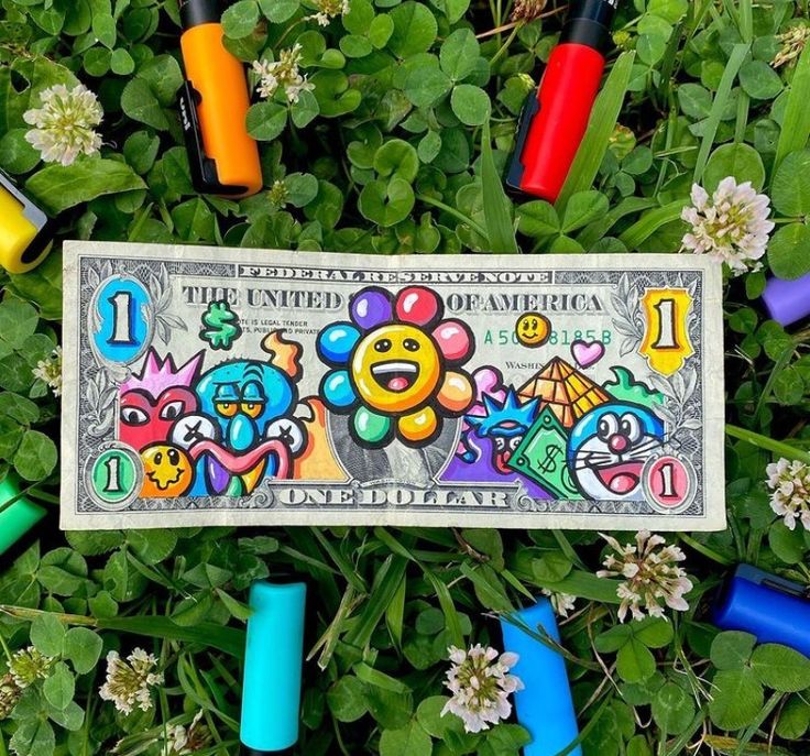 a one dollar bill is surrounded by crayons and markers in the grass,