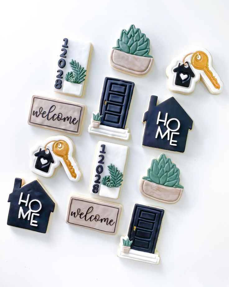 decorated cookies are arranged in the shape of houses and welcome home signs with keys to each door