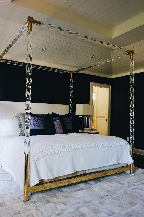 a white bed sitting in a bedroom on top of a hard wood floor