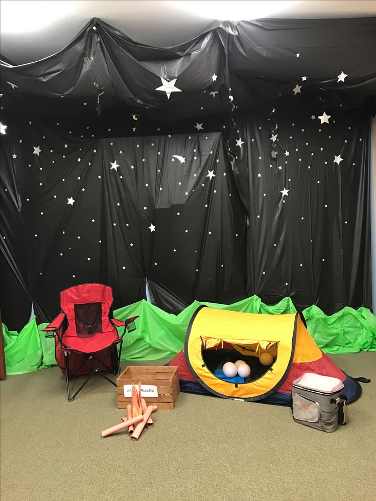 there is a tent and chairs in the room with stars on the wall behind it