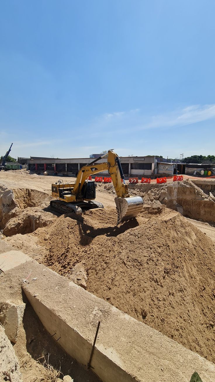 an excavator digs through the dirt at a construction site