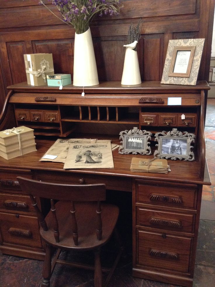 an old desk with flowers and pictures on it