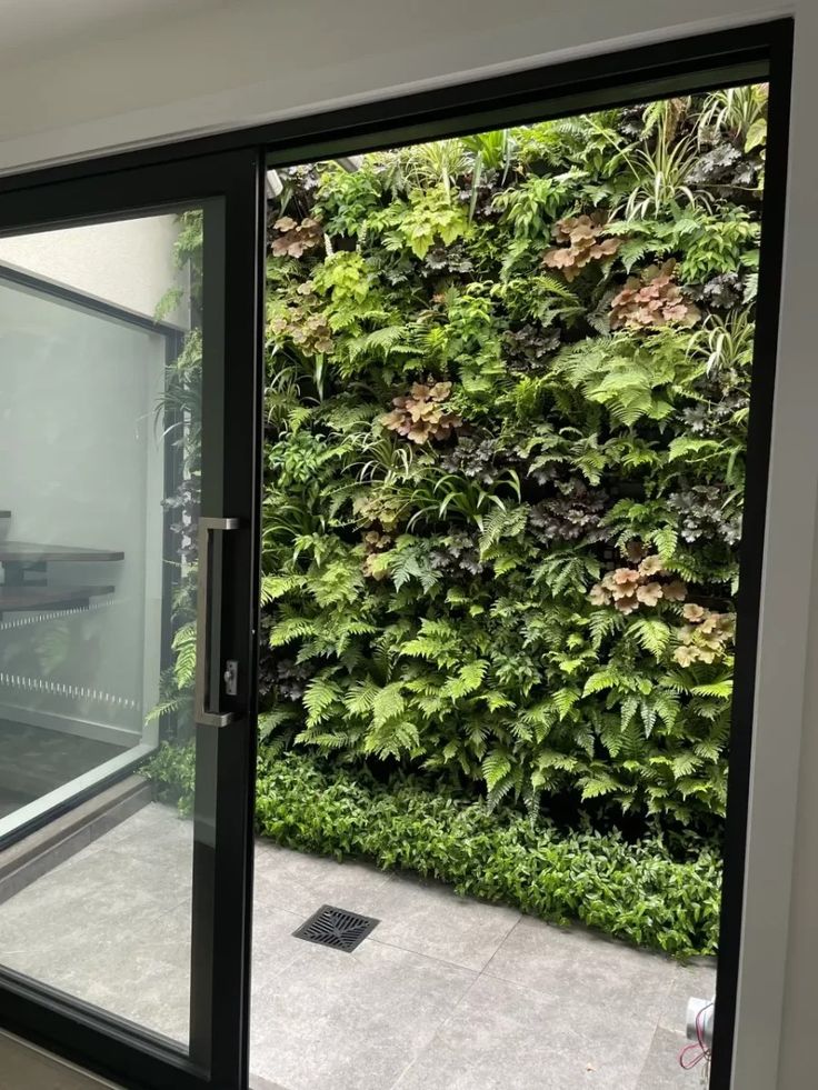 an office with a green wall and glass doors leading to the outside patio area is shown