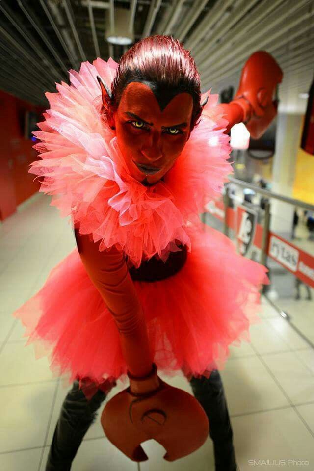 a woman dressed in red and black is posing for the camera