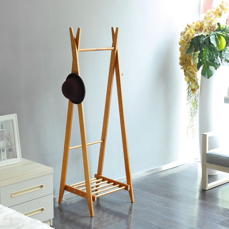 a room with a bed, chair and coat rack