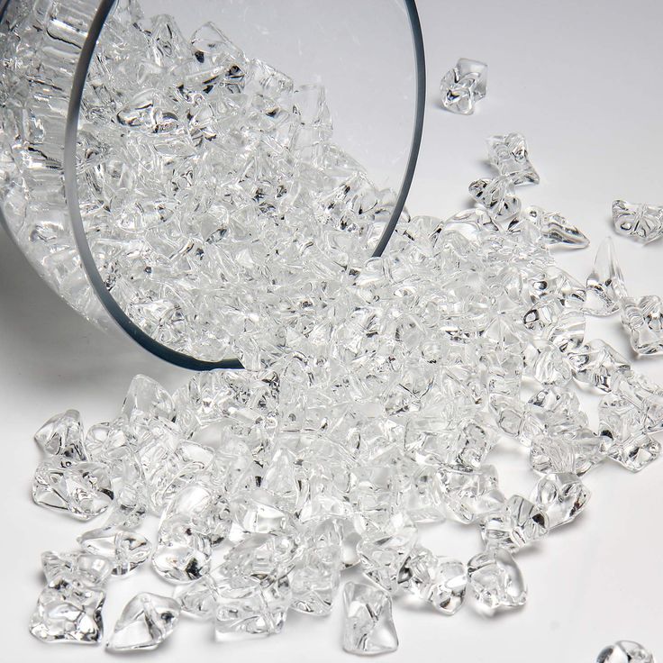 clear crystal beads are scattered on a white surface