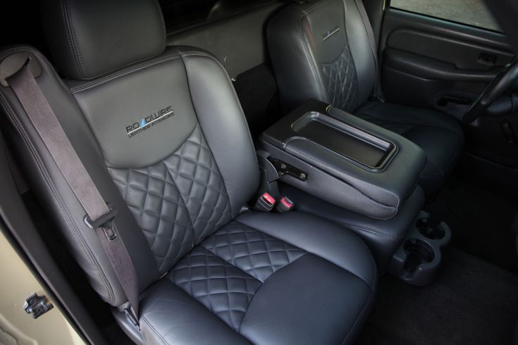 the interior of a car with black leather and grey seats, including an arm rest