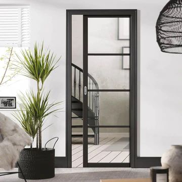 a living room filled with furniture and a tall plant next to a doorway that leads to a staircase