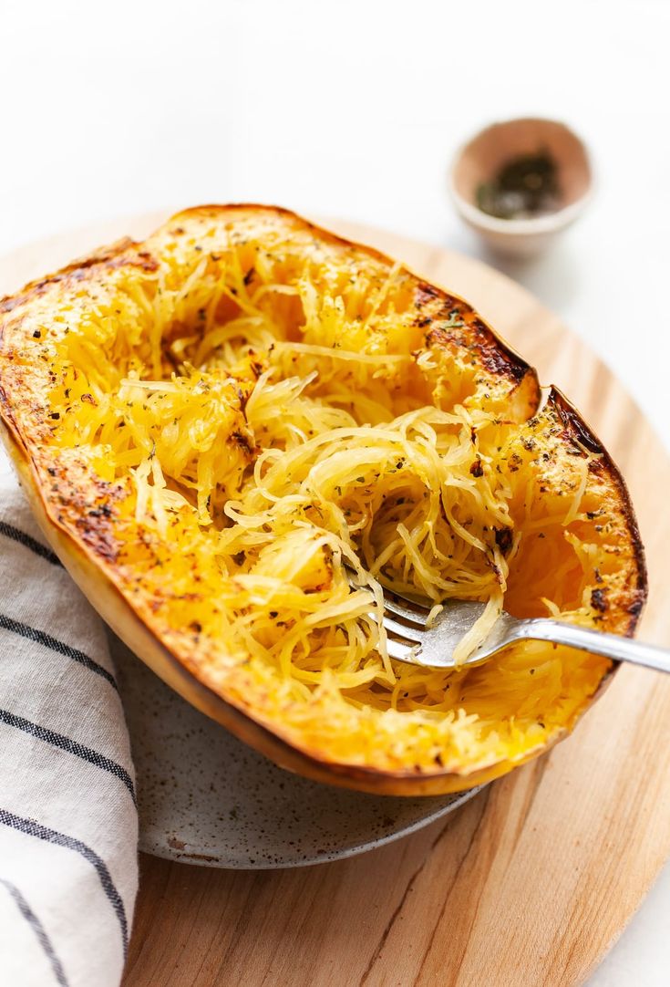 a plate with spaghetti on it and a fork in the bowl, next to some napkins