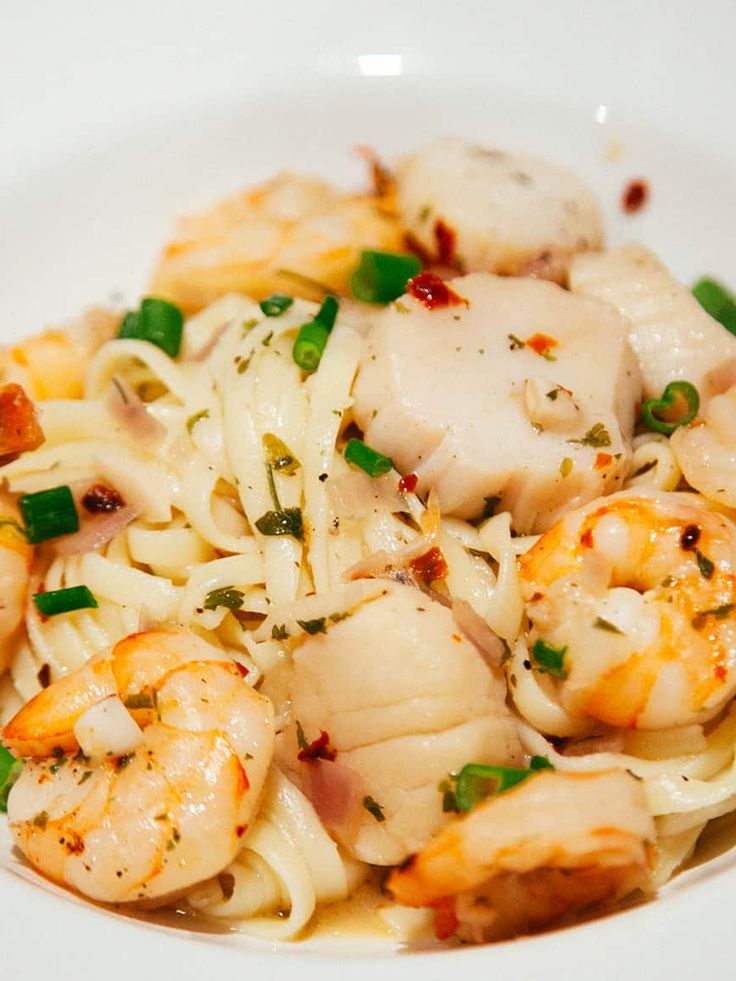 pasta with shrimp and scallops in a white bowl