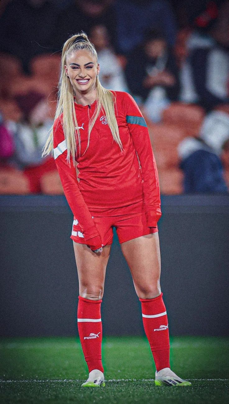 a female soccer player is standing on the field