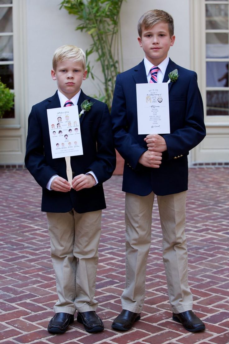 two young boys wearing suits and ties holding papers