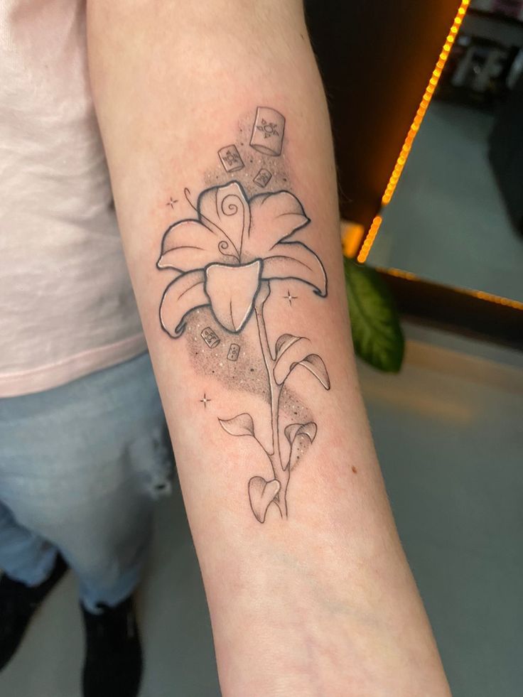 a woman's arm with a tattoo on it that has a flower in the center