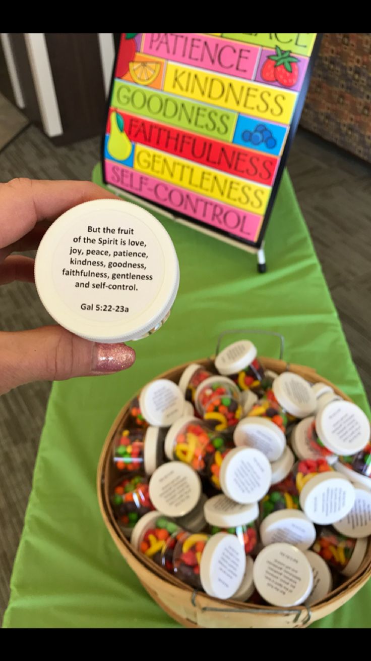 a person holding up a small container of candy