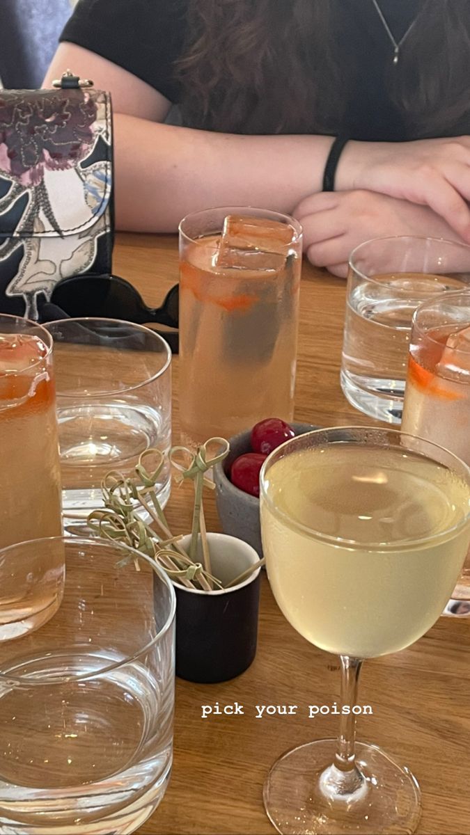 there are many glasses on the table with different drinks in them and one is empty