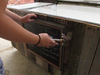 a person writing on a blackboard outside