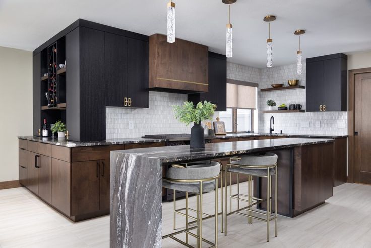 a kitchen with marble counter tops and bar stools next to an island in the middle