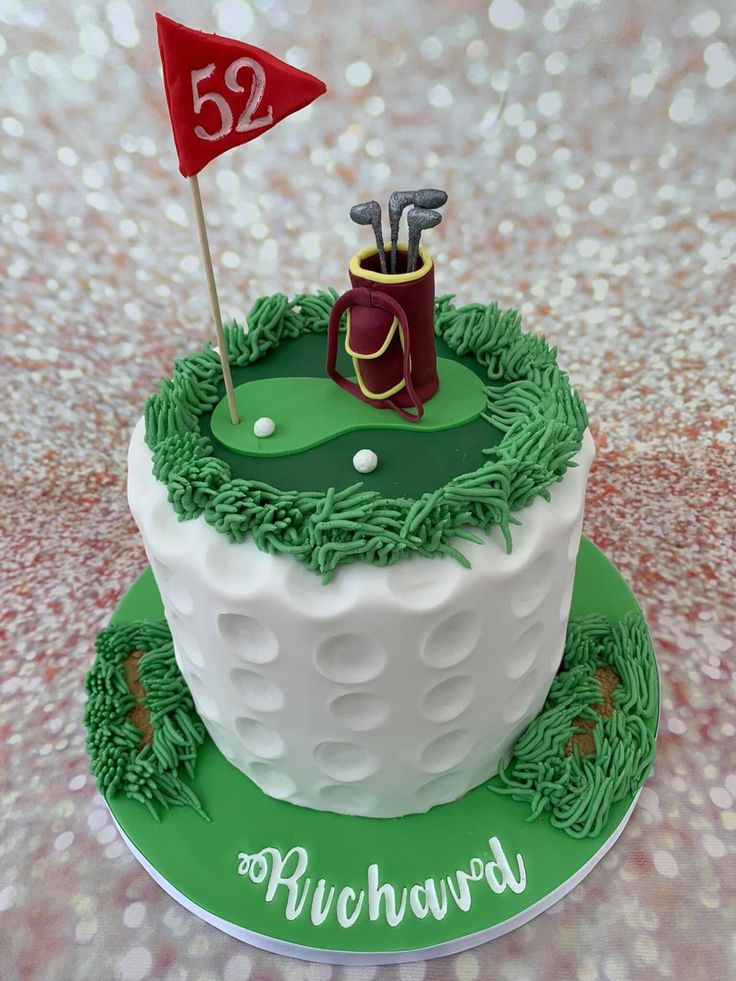 a cake decorated with green frosting and white icing has a golf theme on it