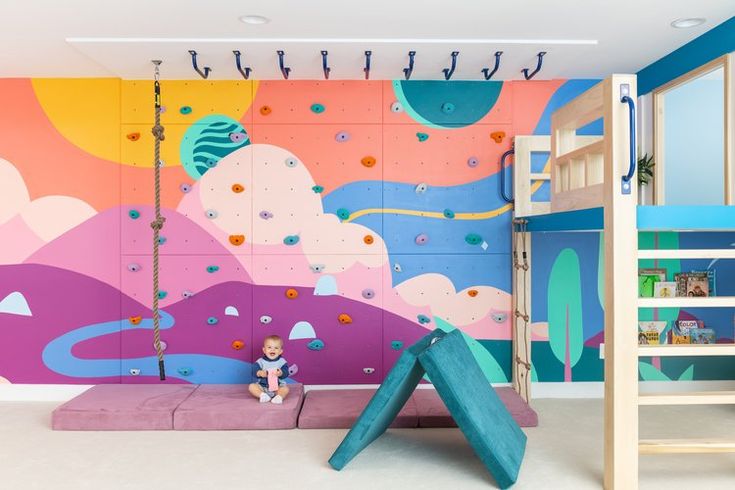 a child's bedroom with climbing wall and bunk beds, painted in bright colors