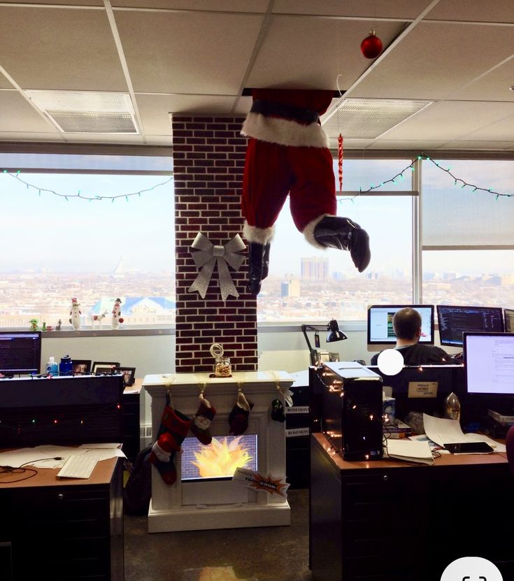 an office cubicle decorated for christmas with santa's stocking hanging from the ceiling