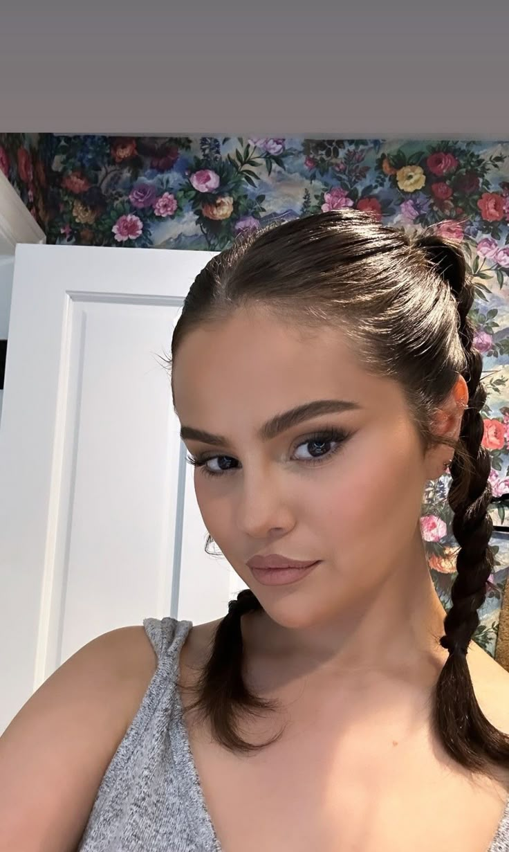 a woman with braids in her hair posing for the camera