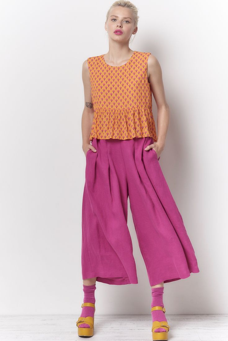 The Trudy pant is high waisted cropped pant. There are 2 button tabs on the front waist and stitched elastic on the back waist. Shown here in our Dyed Linen. Content: 100% Linen Color: Fuchsia Fits: Fitted waist with a full leg Sizes: XS-L What we Love: Great styling and fit Made In Los Angeles with Love Model is 5'9" size 2 and is wearing a size S *Mask sold separately Measurements are taken relaxed, take your normal size Spring Cropped Pants With Relaxed Fit, Cropped Wide Leg Pants For Summer Workwear, Relaxed Fit Linen Cropped Bottoms, Relaxed Fit Cropped Linen Bottoms, Cropped Linen Workwear Bottoms, Casual Summer Culottes With Belt Loops, Cropped Pants With Pockets For Spring, Spring Cropped Bottoms With Loosely Fitted Hips, Cropped Cotton Bottoms With Belt Loops