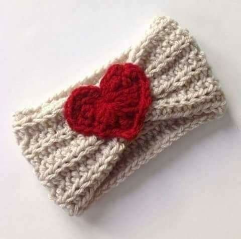 a crocheted headband with a red heart on the front and white background