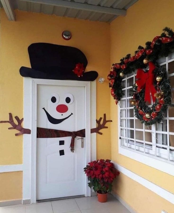 a snowman door decorated with wreaths and decorations