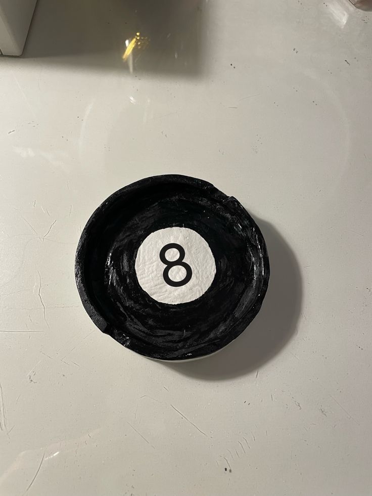 a black and white eight ball holder on a counter top with the number 8 in it