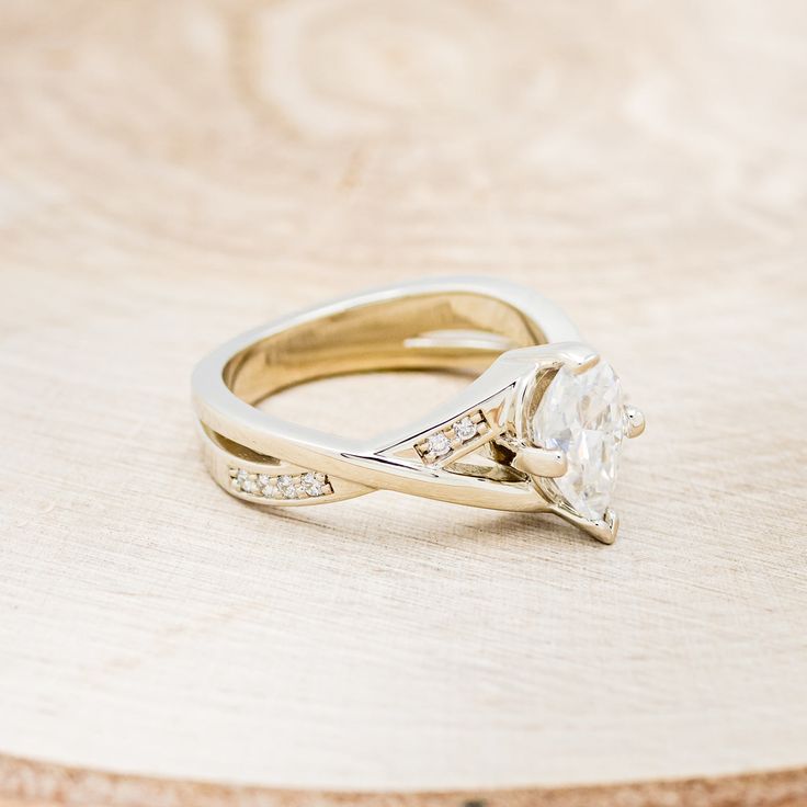 a diamond ring sitting on top of a wooden table