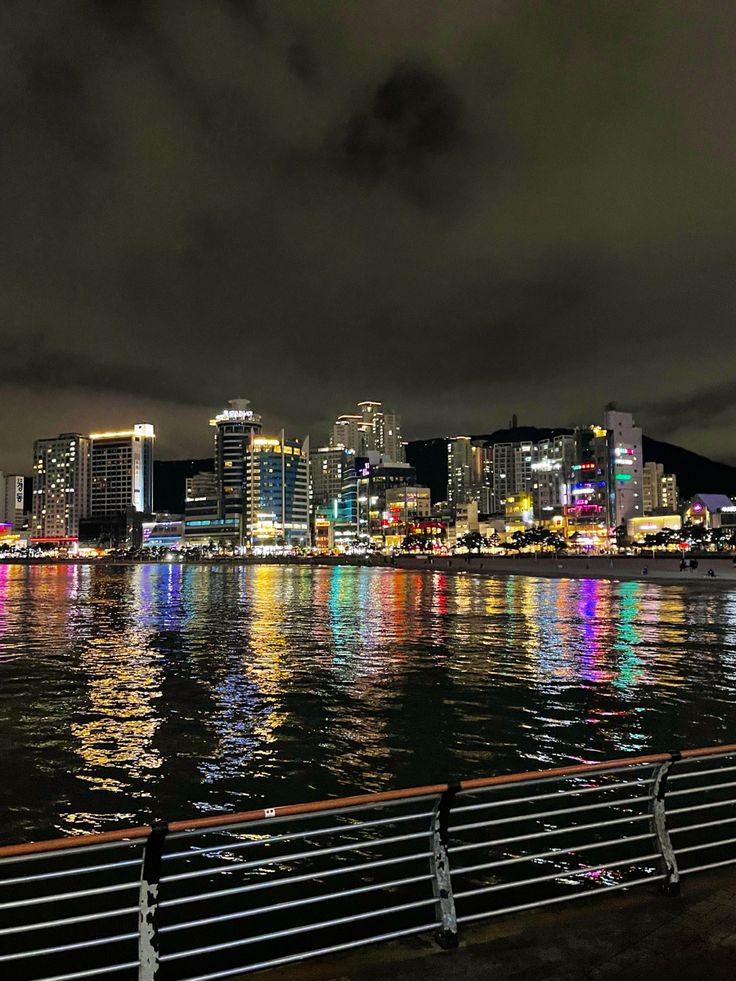 the city lights are reflected in the water