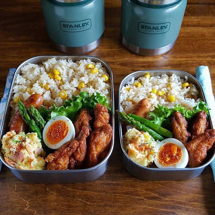 two tins filled with food on top of a wooden table