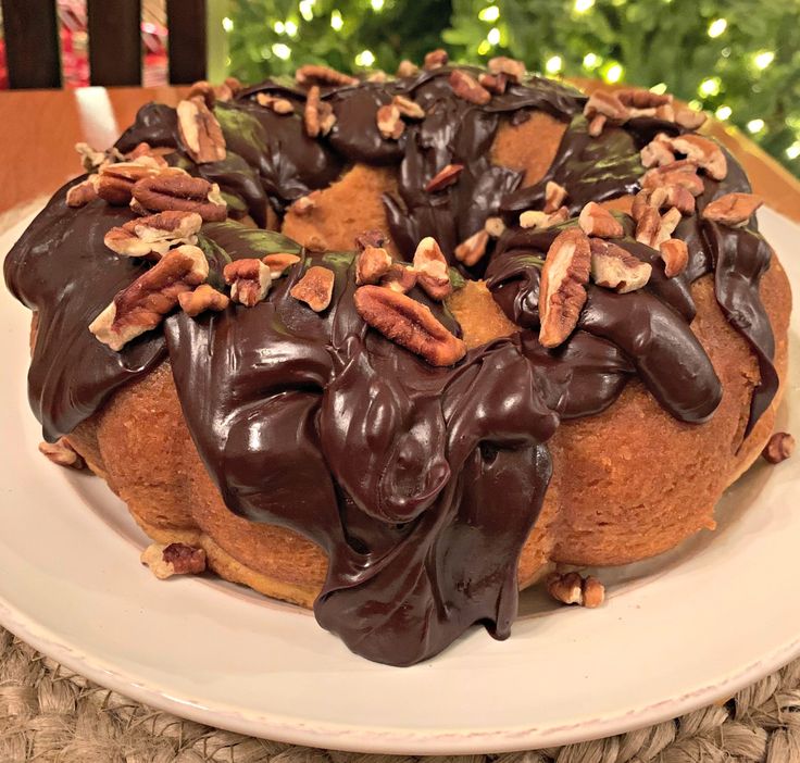 a chocolate frosted bundt cake with pecans on top